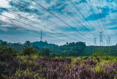 Electricity pylon on field against sky