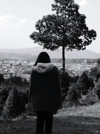 Rear view of woman standing on landscape against clear sky