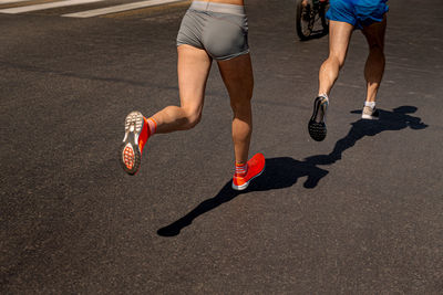 Low section of woman walking on road