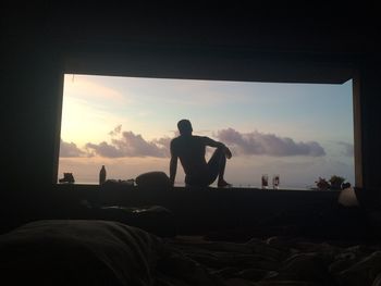 Rear view of silhouette man and people looking at sunset