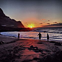 Silhouette of people at beach during sunset