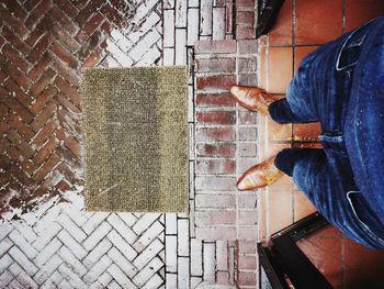 Low section of man standing by wall