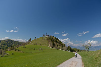 View of field against cloudy sky