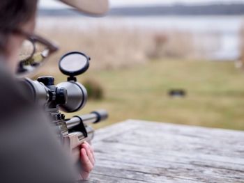 Rear view of woman holding rifle 