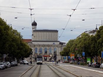 Cars on street in city against sky