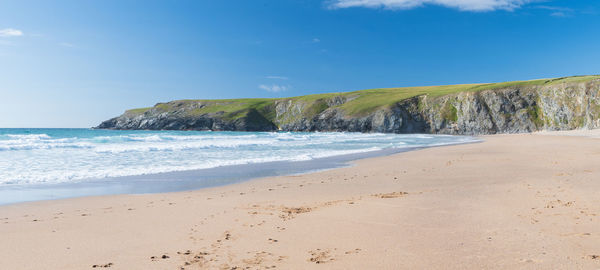 Panoramic photo of the beach and cliffs at holywell bay in cornwall