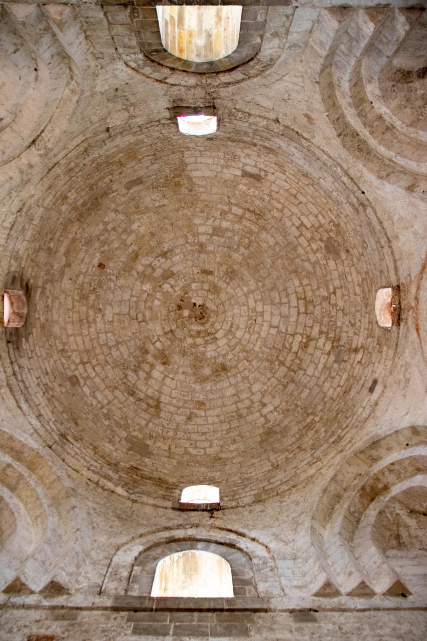 ancient history, ceiling, architecture, wood, no people, built structure, indoors, pattern, history, arch, circle, lighting equipment, the past, geometric shape, low angle view, old, day, backgrounds, textured, shape, temple, religion