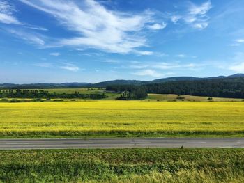 Scenic view of field against cloudy sky