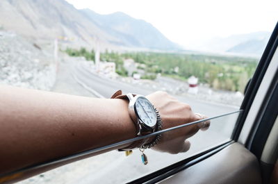 Cropped hand on car window