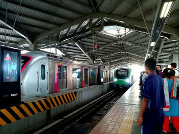 Rear view of woman standing on railroad station platform