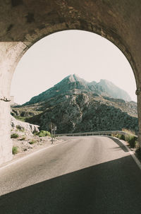 Road by mountains against clear sky