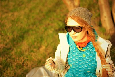 Portrait of young woman wearing sunglasses standing outdoors