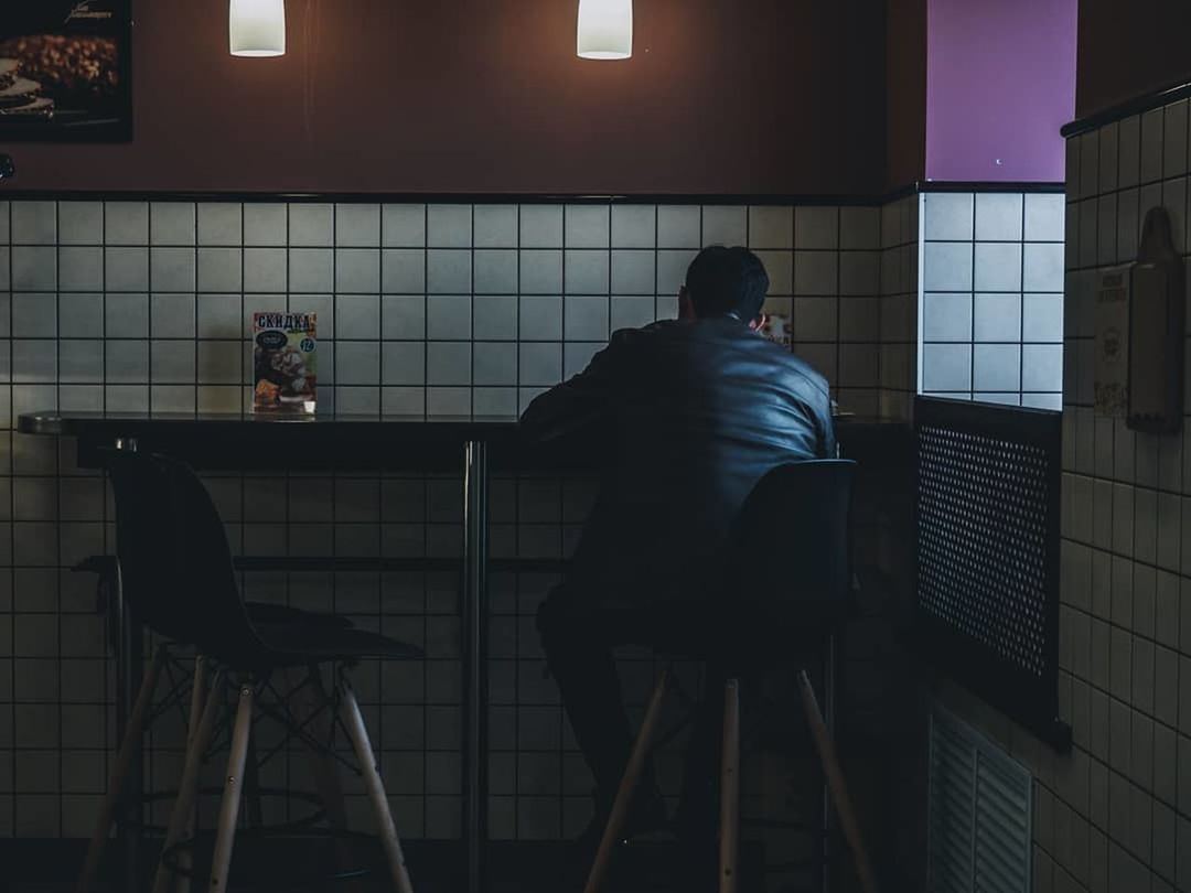 men, sitting, adult, light, one person, indoors, seat, furniture, rear view, interior design, clothing, person, night, full length, architecture, chair, business, lighting
