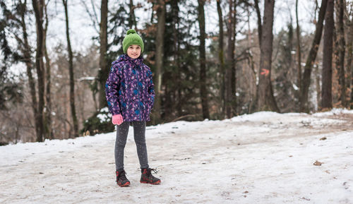 Portrait of boy standing on snow covered land