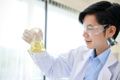 Side view of scientist holding dentures in laboratory