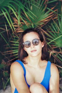 Portrait of beautiful woman sitting on sand at beach