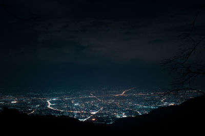 Illuminated cityscape against sky at night