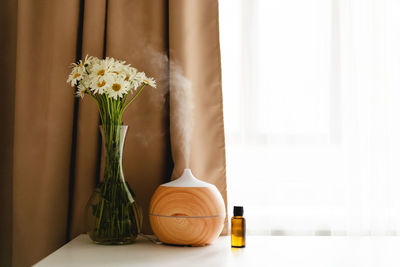 Aromatherapy concept. aroma oil diffuser on the table against the window.