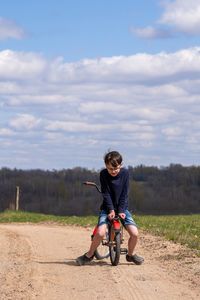 Full length of boy riding motorcycle on road