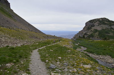 Scenic view of road by mountains against sky