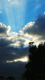 Silhouette of trees against cloudy sky