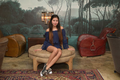 Portrait of young woman sitting on chair