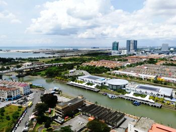 High angle view of river amidst buildings in city against sky