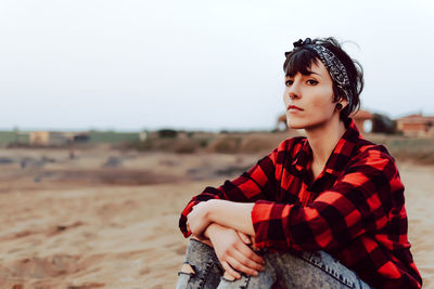 Portrait of beautiful woman sitting on land