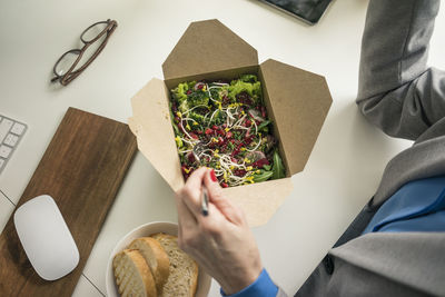 Woman eating salad for lunch at her desk