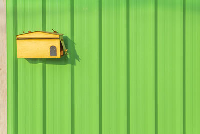 Birdhouse on green corrugated iron