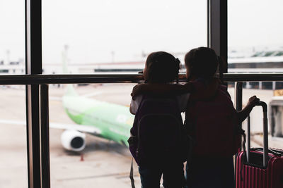 Rear view of couple kissing at airport