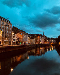 Reflection of buildings in river against sky