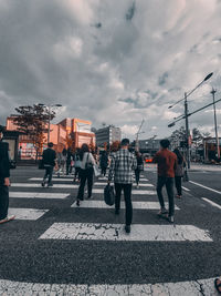 People crossing road against sky