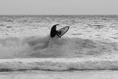 Man surfing in sea against clear sky
