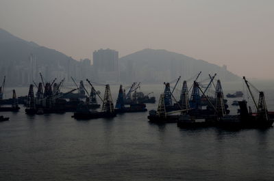 Cranes at victoria harbor against sky