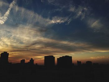 Silhouette buildings against sky during sunset