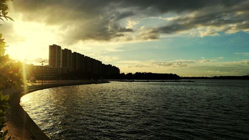 River by city against sky during sunset