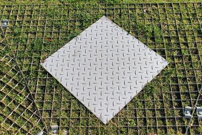 High angle view of diamond plate on grassy field