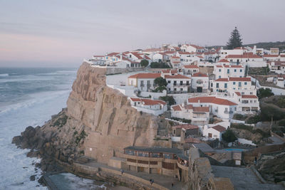 High angle view of townscape by sea against sky