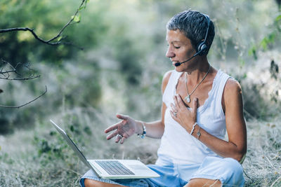 Young man using mobile phone while sitting outdoors