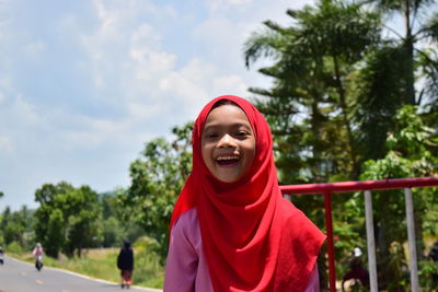 Portrait of girl in hijab against trees and sky