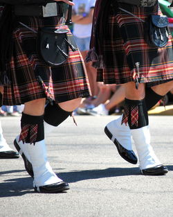 Scottish band marching in a parade outdoors.