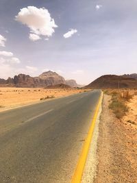 Road leading towards desert against sky