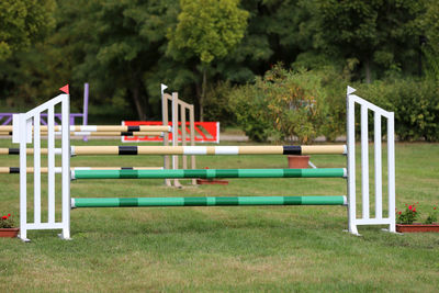 Empty benches on field against trees