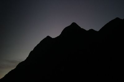 Low angle view of silhouette mountain against clear sky