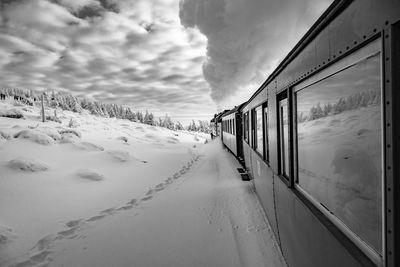 Scenic view of snow covered train against sky