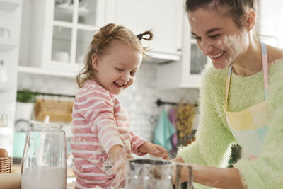 Mother and daughter preparing food in kitchen at home