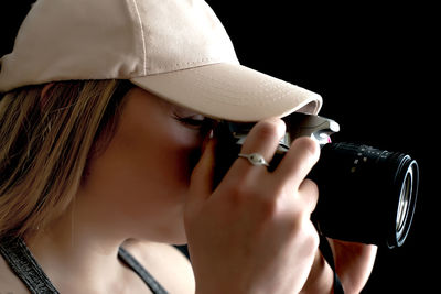 Woman photographing against black background