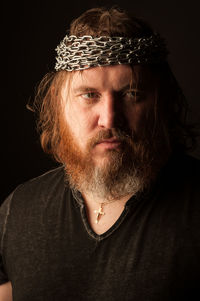 Portrait of man wearing mask against black background