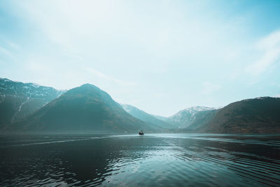 Scenic view of lake by mountains against sky